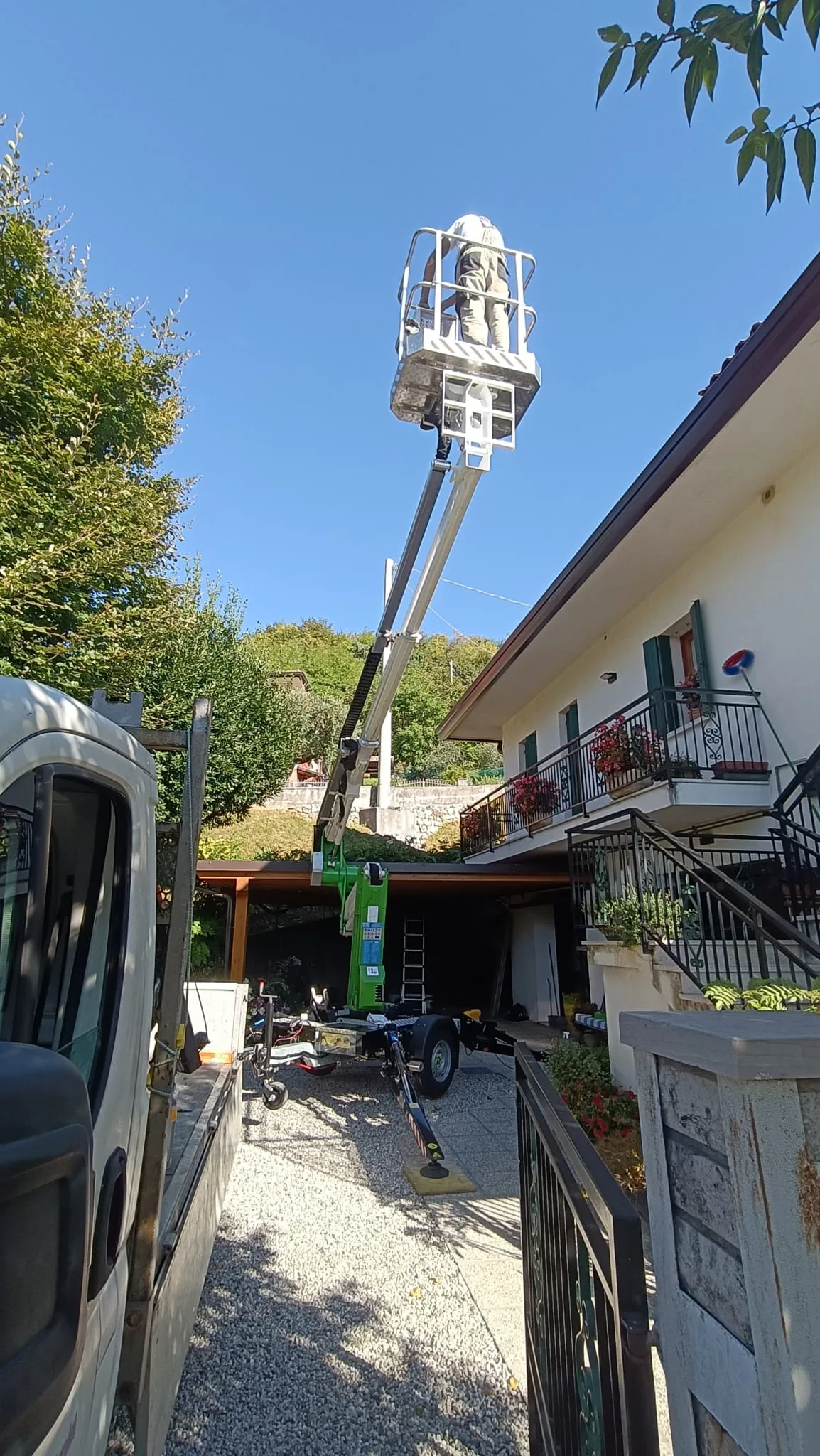 Intervento di manutenzione tetti e canne fumarie con cestello elevatore su villa