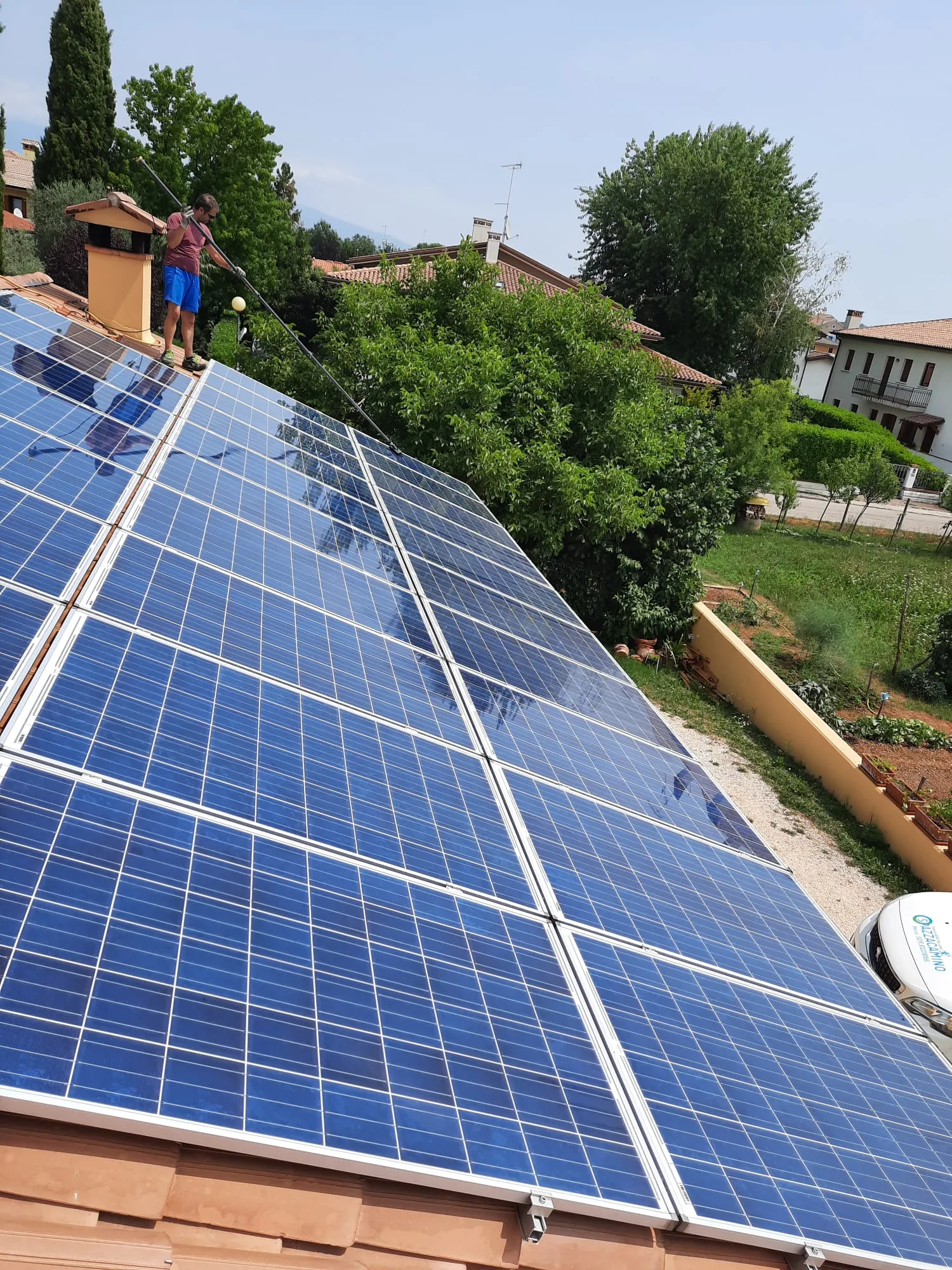 Tecnico Mega pulizie al lavoro con asta telescopica e furgone aziendale a Treviso